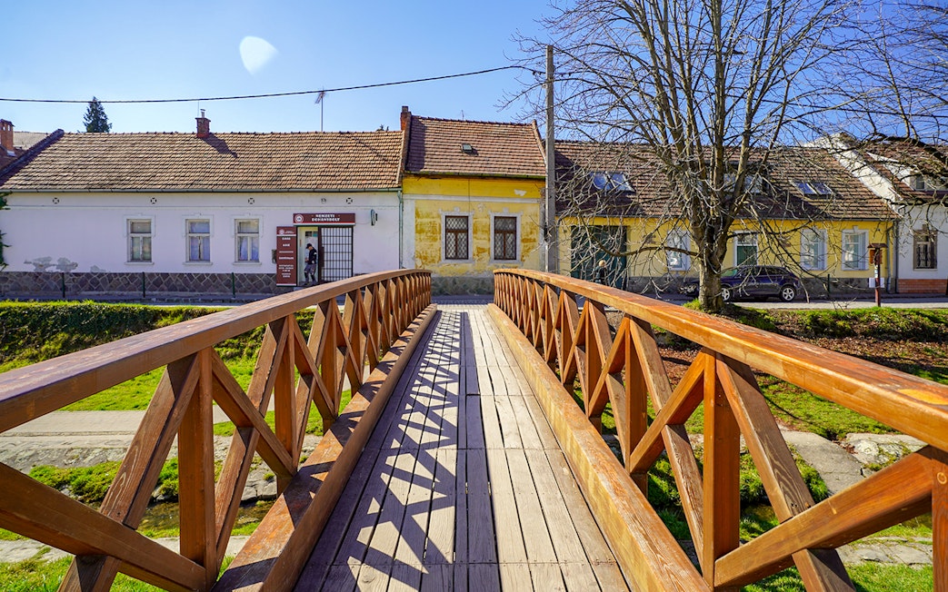 Wooden bridge leading to colorful houses in Szentendre village, Hungary.