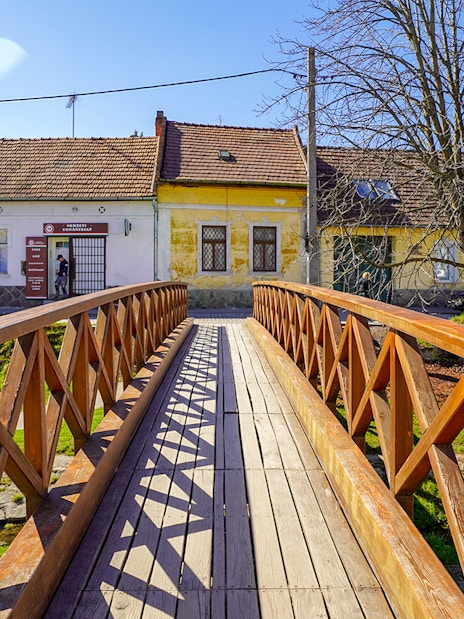 Wooden bridge leading to colorful houses in Szentendre village, Hungary.