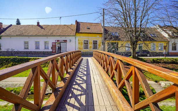 Wooden bridge leading to colorful houses in Szentendre village, Hungary.
