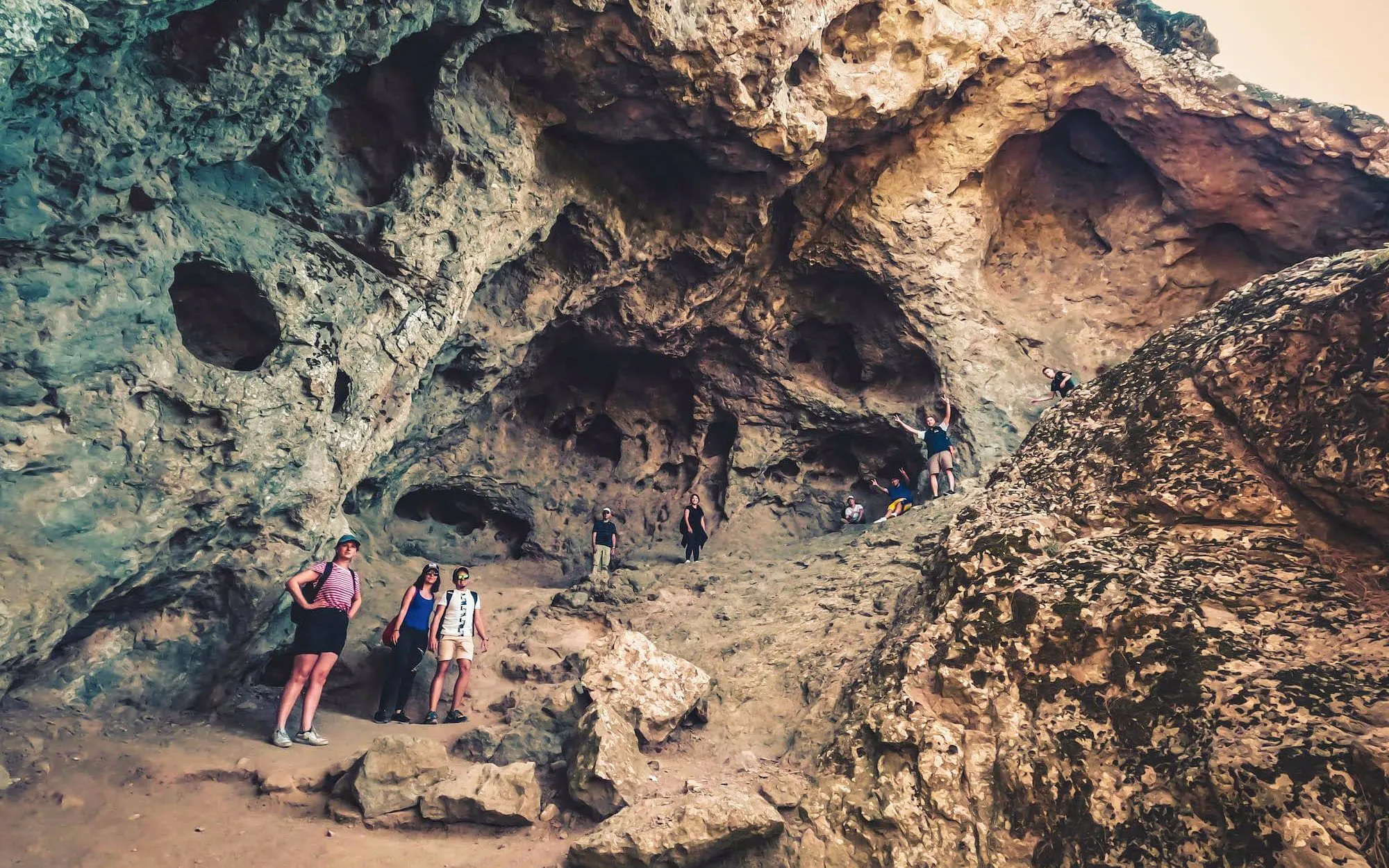 Tourists exploring volcanic rock formations in Gran Canaria during sunset tour.