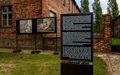 Informative sign at Auschwitz-Birkenau detailing historical context and prisoner experiences.