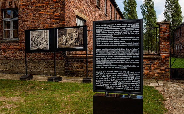 Informative sign at Auschwitz-Birkenau detailing historical context and prisoner experiences.