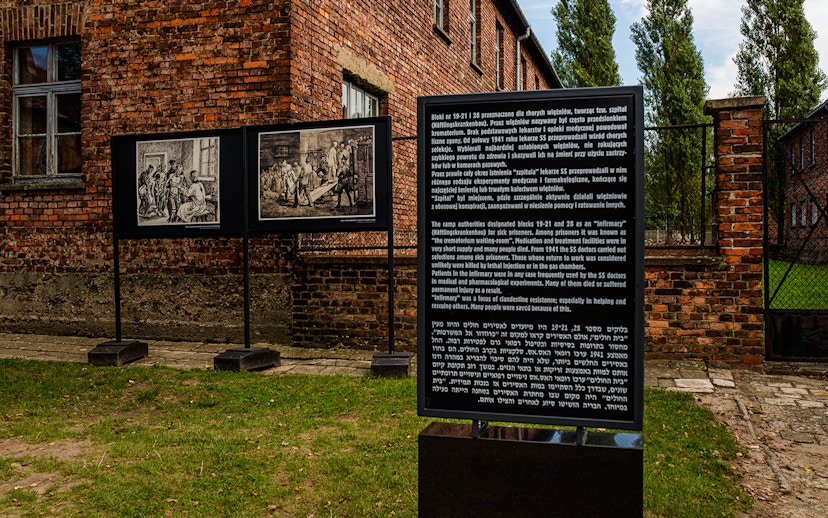 Informative sign at Auschwitz-Birkenau detailing historical context and prisoner experiences.