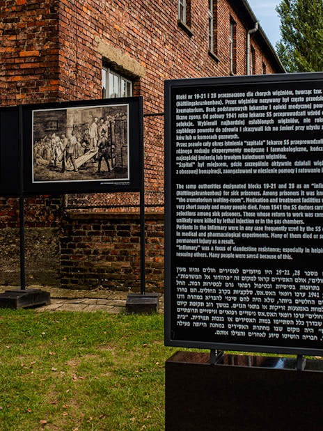Informative sign at Auschwitz-Birkenau detailing historical context and prisoner experiences.