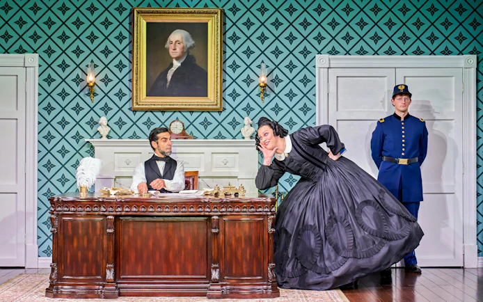 Theatrical scene with historical figures in a vintage office setting, Oh Mary! tour.