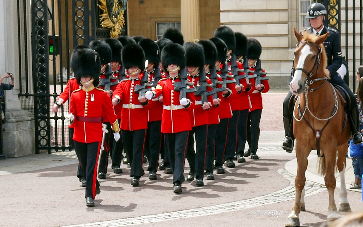 Guards in red uniforms marching at the Changing of the Guards ceremony, London.