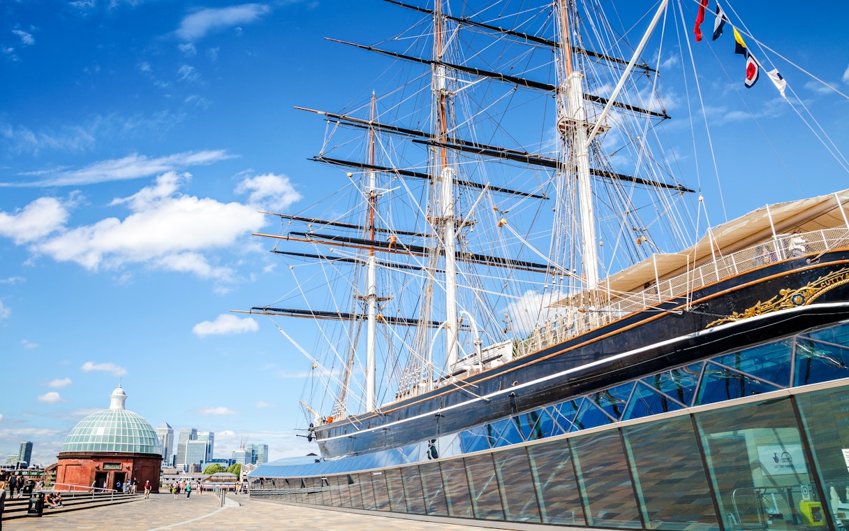 Cutty Sark ship in Greenwich, London, with city skyline in the background.