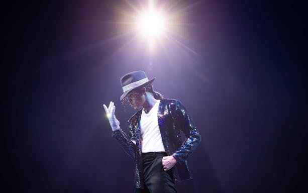 Performer in MJ the Musical on stage in Brisbane, wearing a sequined jacket and fedora.