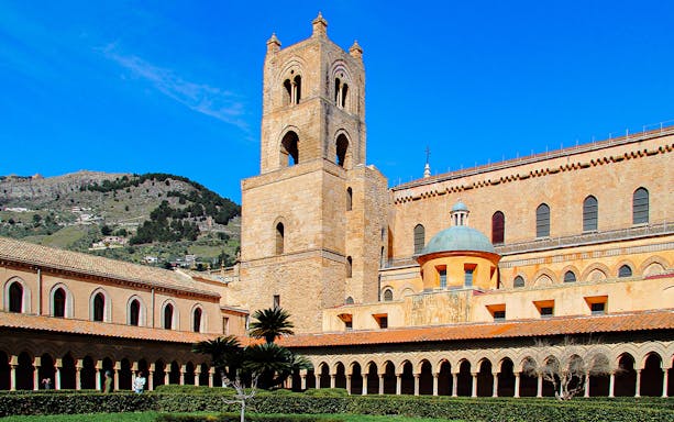 Monreale Cathedral exterior with bell tower and courtyard, Sicily.