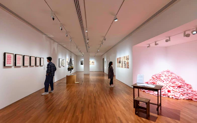 Visitors viewing art exhibits inside National Gallery Singapore.