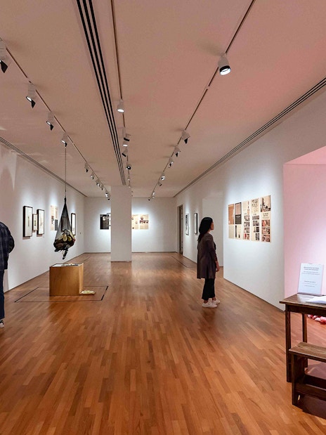 Visitors viewing art exhibits inside National Gallery Singapore.