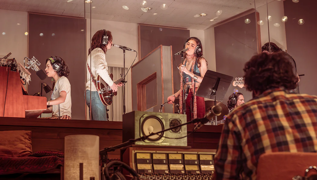 Recording session in a studio with musicians playing instruments and singing, related to Stereophonic.