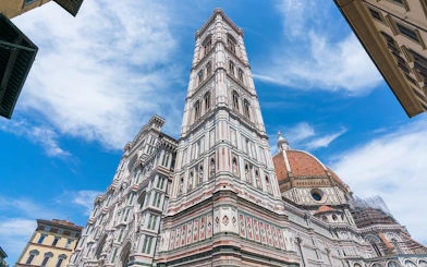 Giotto's Bell Tower beside Florence Cathedral under blue sky, part of Florence in a Day tour.