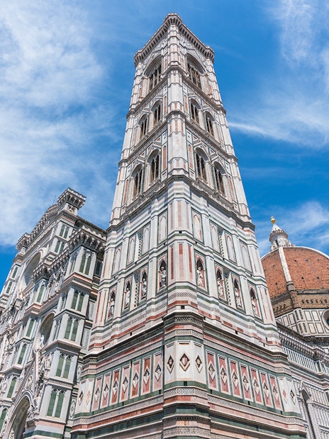 Giotto's Bell Tower beside Florence Cathedral under blue sky, part of Florence in a Day tour.