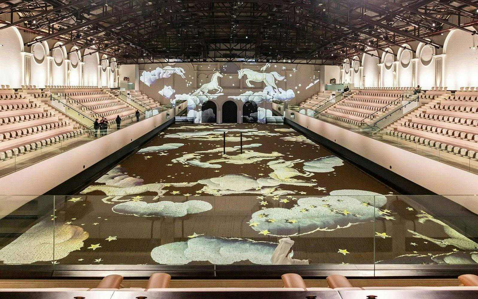 Abu Dhabi equestrian arena with horse projections on the floor and walls.