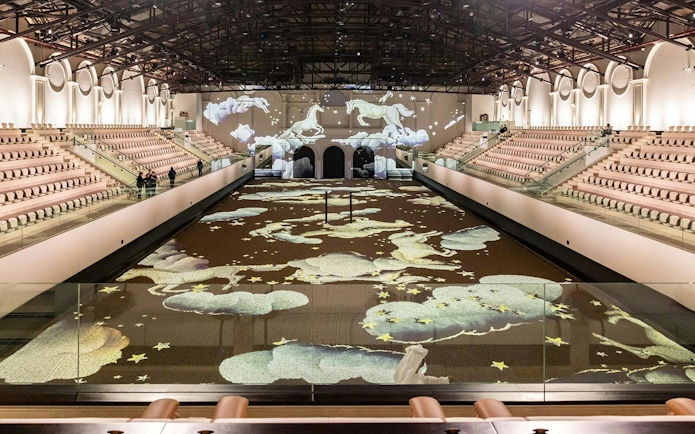 Abu Dhabi equestrian arena with horse projections on the floor and walls.