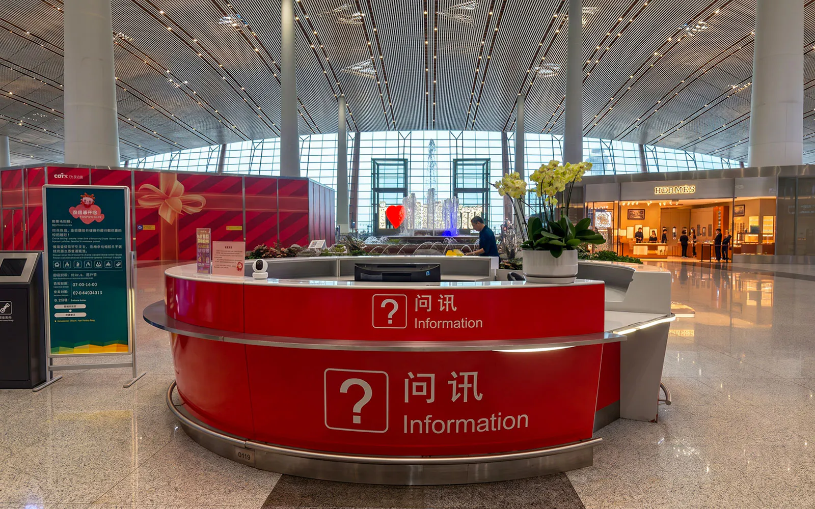 Information desk at Terminal 3, Beijing Capital Airport with shops in the background.