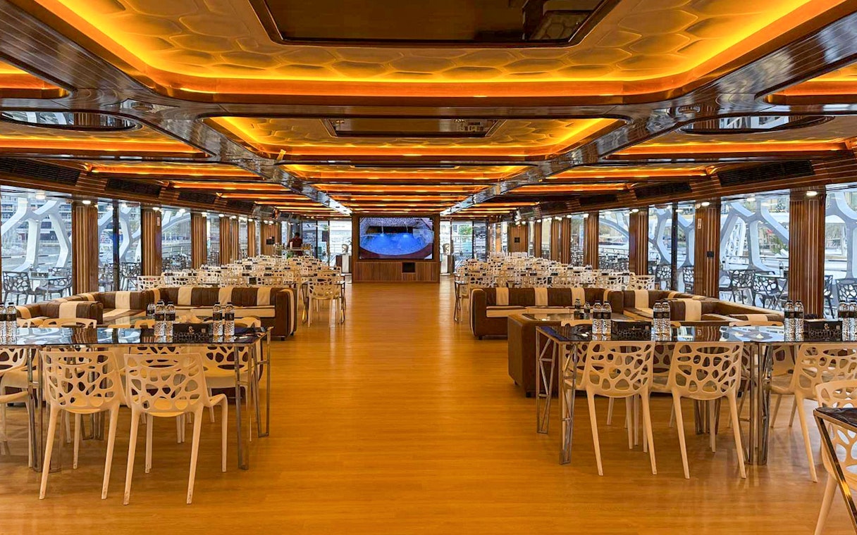 Luxurious dining area on Lotus Mega Yacht in Dubai Marina with tables set for buffet dinner.
