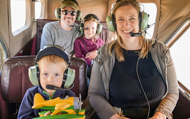 Family enjoying Golden Gate Seaplane Tour with headsets inside aircraft.