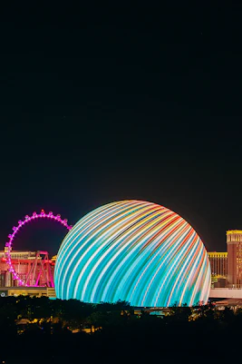 Exterior view of illuminated Sphere in Las Vegas skyline at night.