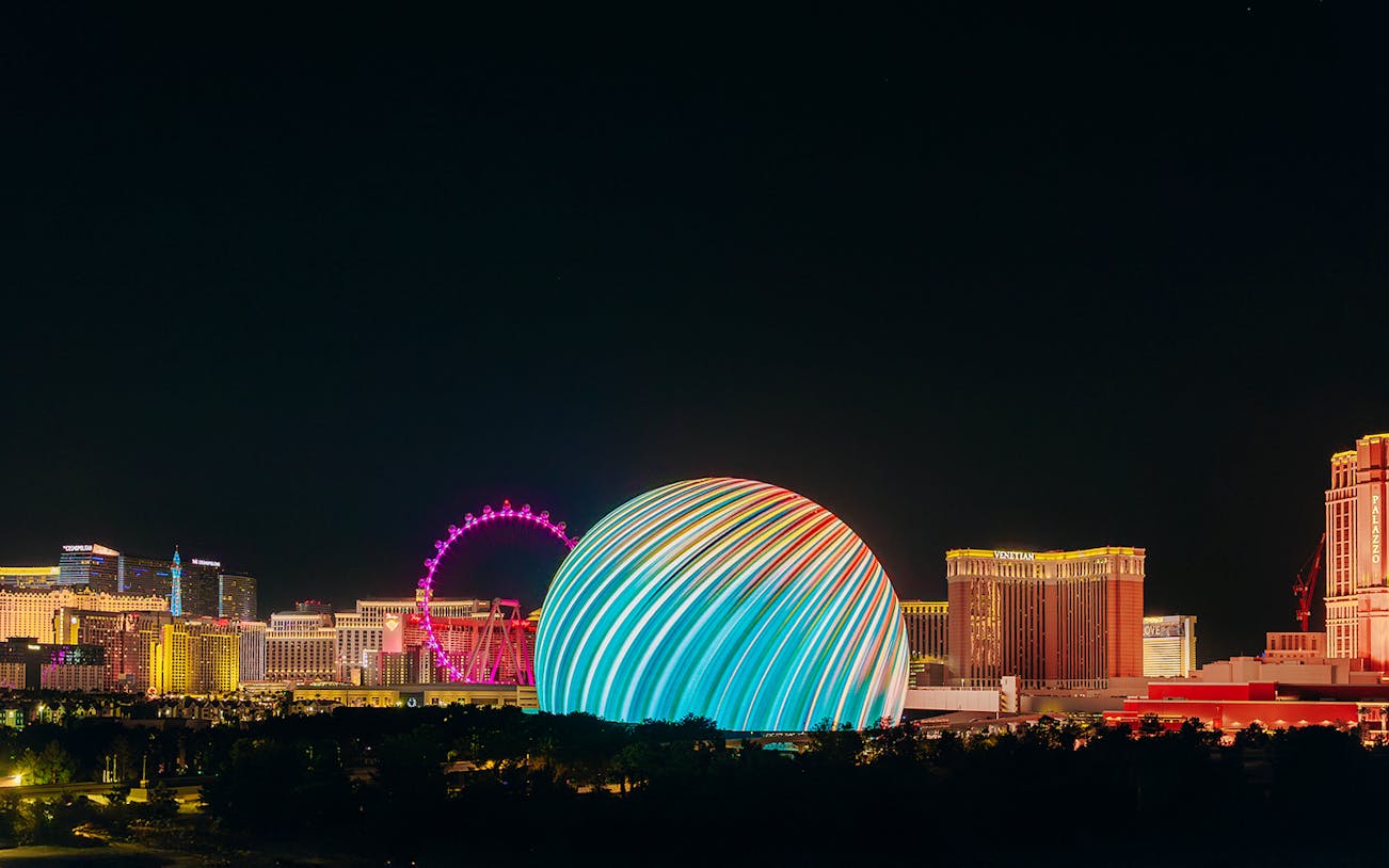 Exterior view of illuminated Sphere in Las Vegas skyline at night.