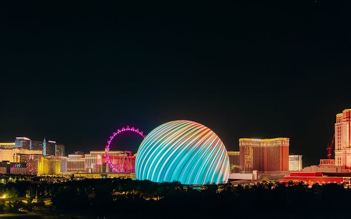 Exterior view of illuminated Sphere in Las Vegas skyline at night.