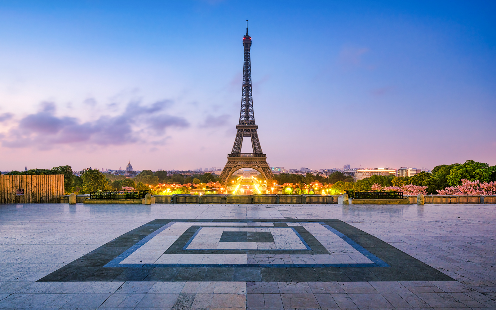 Eiffel Tower illuminated at dusk in Paris, France, viewed from Trocadéro Gardens.