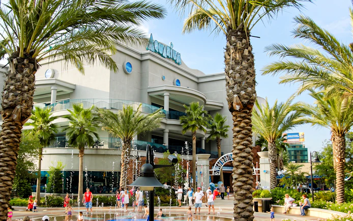 Downtown Aquarium Houston entrance with palm trees and visitors.