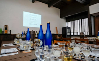 Sake bottles and tasting glasses on table at Kyoto Insider Sake Experience.
