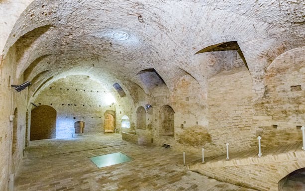 Ducal Palace interior with arched brick ceilings and stone floor.