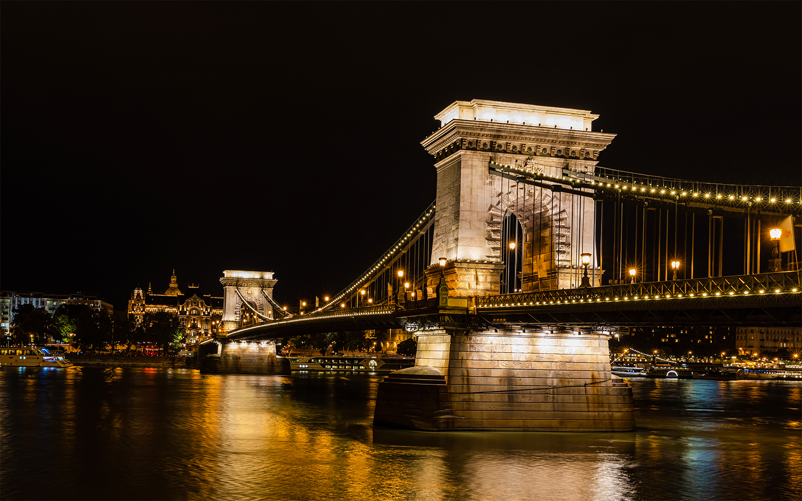 Szechenyi Chain Bridge illuminated at night viewed from a Budapest Danube River dinner cruise.