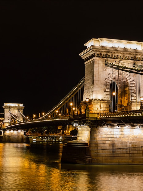 Szechenyi Chain Bridge illuminated at night viewed from a Budapest Danube River dinner cruise.