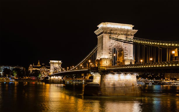 Szechenyi Chain Bridge illuminated at night viewed from a Budapest Danube River dinner cruise.