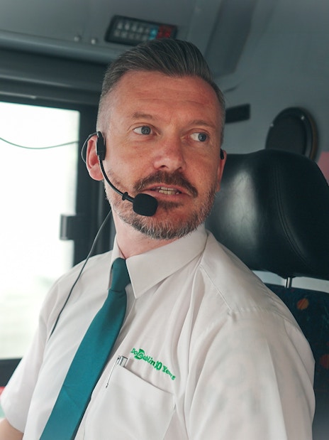 Live guide speaking on hop on hop off bus in Dublin.