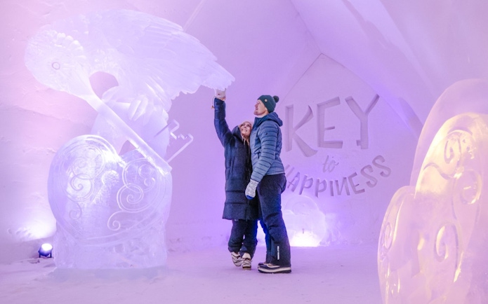 Guests admire ice sculptures inside Arctic SnowHotel.