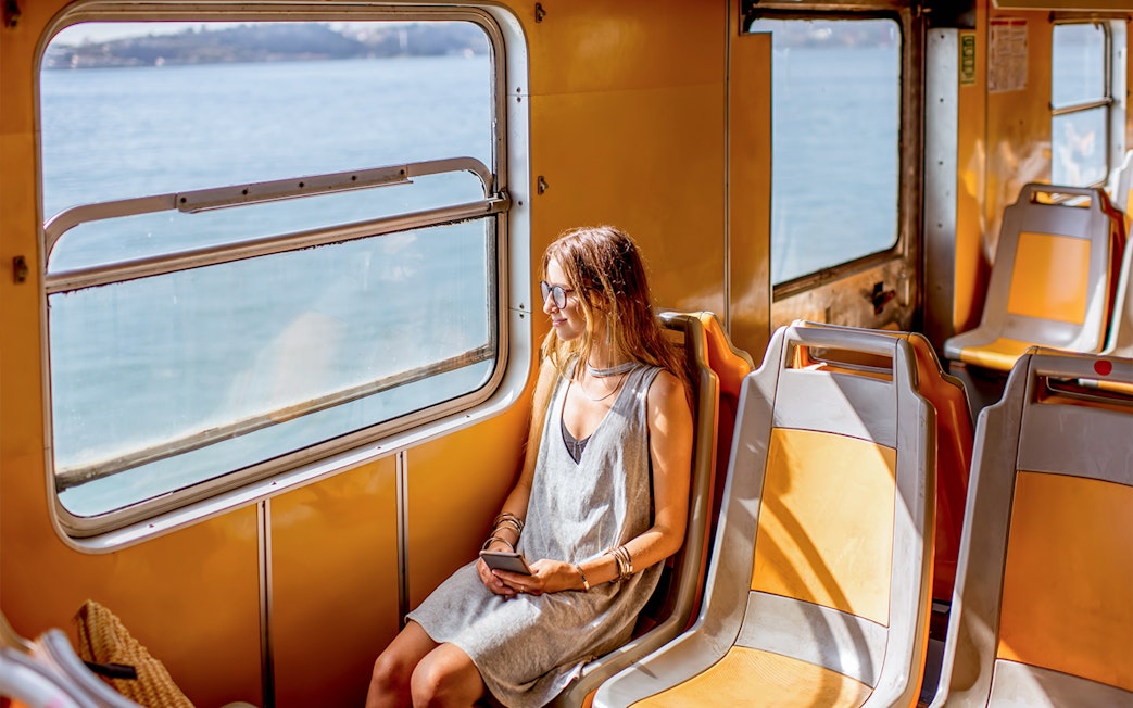 Young woman on a water bus in Venice, looking out at the sea.