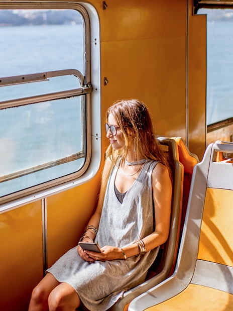 Young woman on a water bus in Venice, looking out at the sea.
