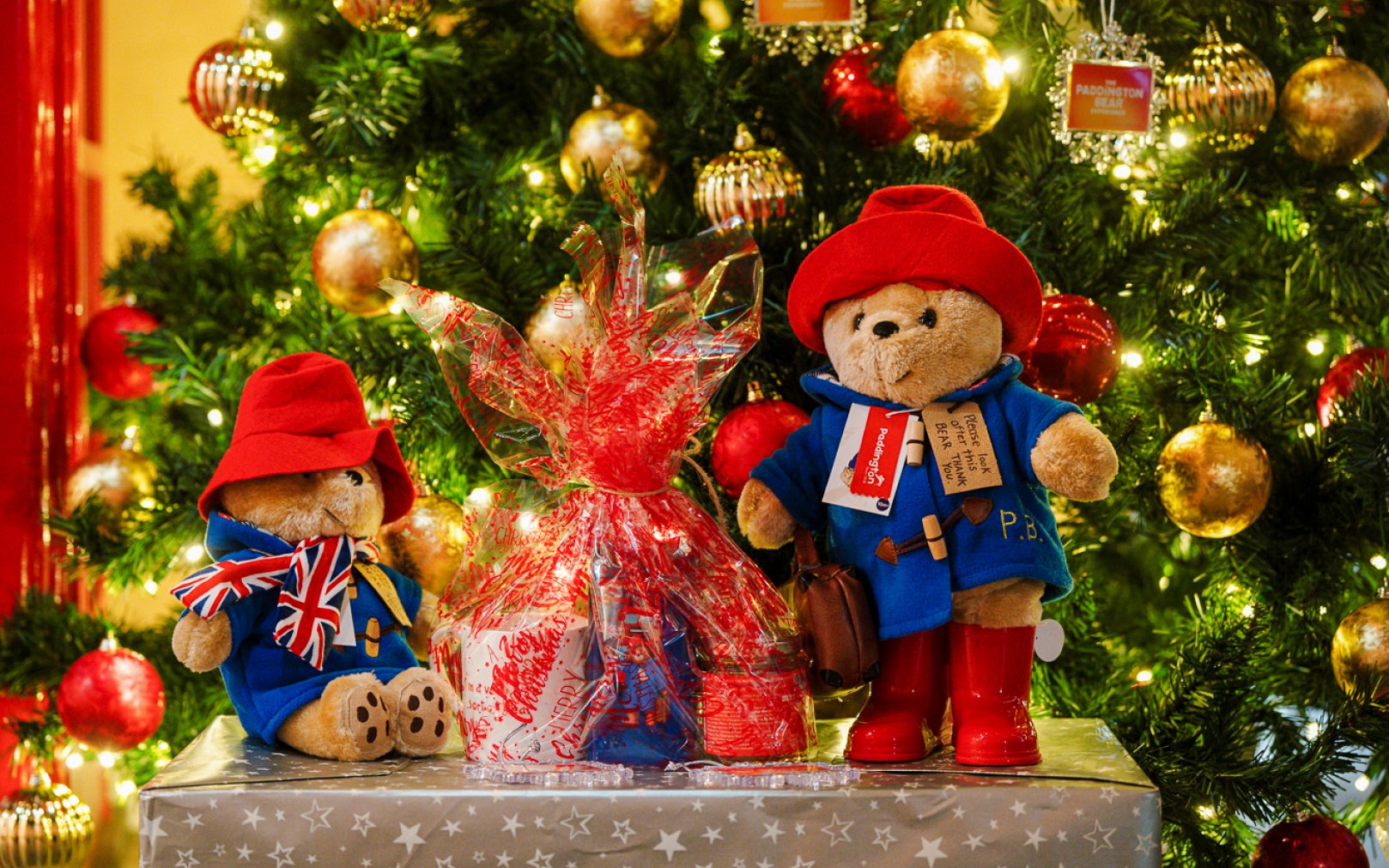 Paddington Bear toys by a decorated Christmas tree in London.