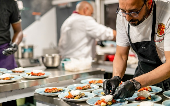 Chef preparing Italian dishes for Le Diamant Bleu dinner cruise in Paris.