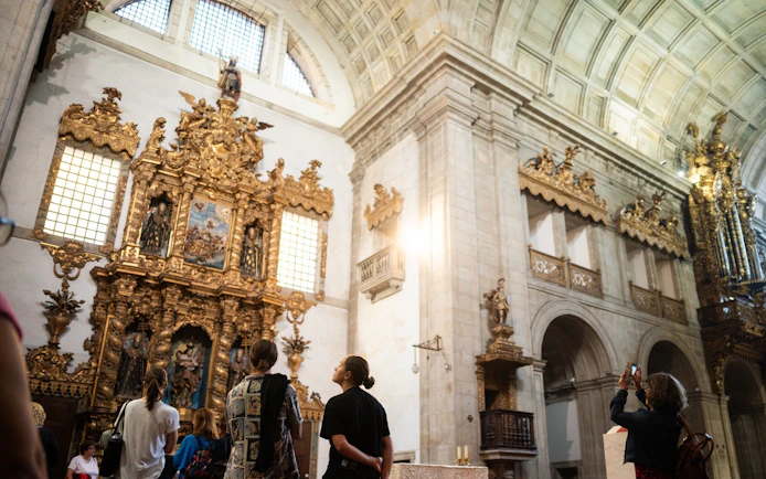 Tourists with guide admiring ornate altar in Monastery of São Bento da Vitória.
