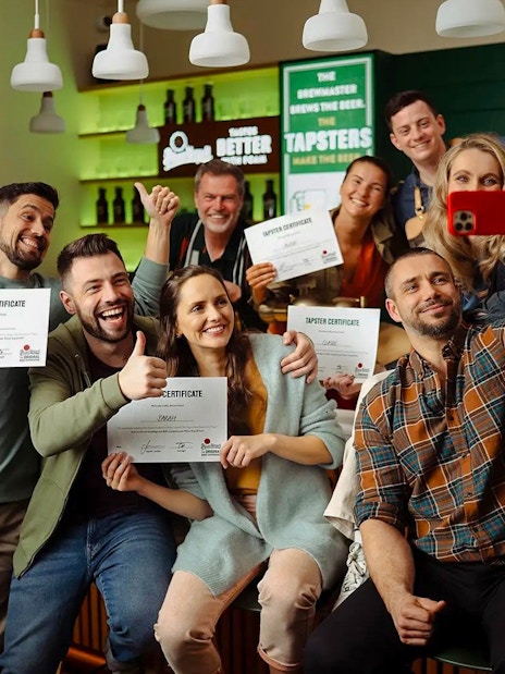 Group holding certificates at Prague Pilsner Urquell Experience bar.