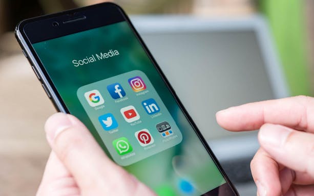 Smartphone displaying social media apps, ideal for 4G prepaid e-sim use in Turkey.
