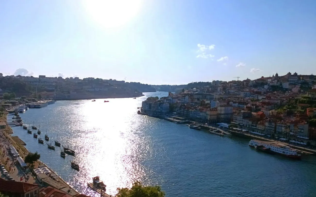 Porto cityscape with Douro River and boats, view from a self-guided exploration game.