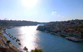 Porto cityscape with Douro River and boats, view from a self-guided exploration game.
