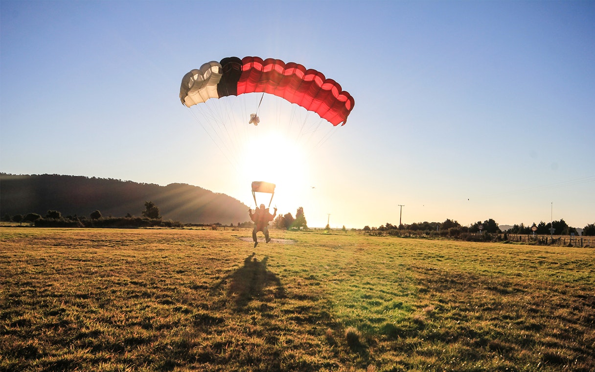 Skydiver landing at sunset in Franz Josef, New Zealand.