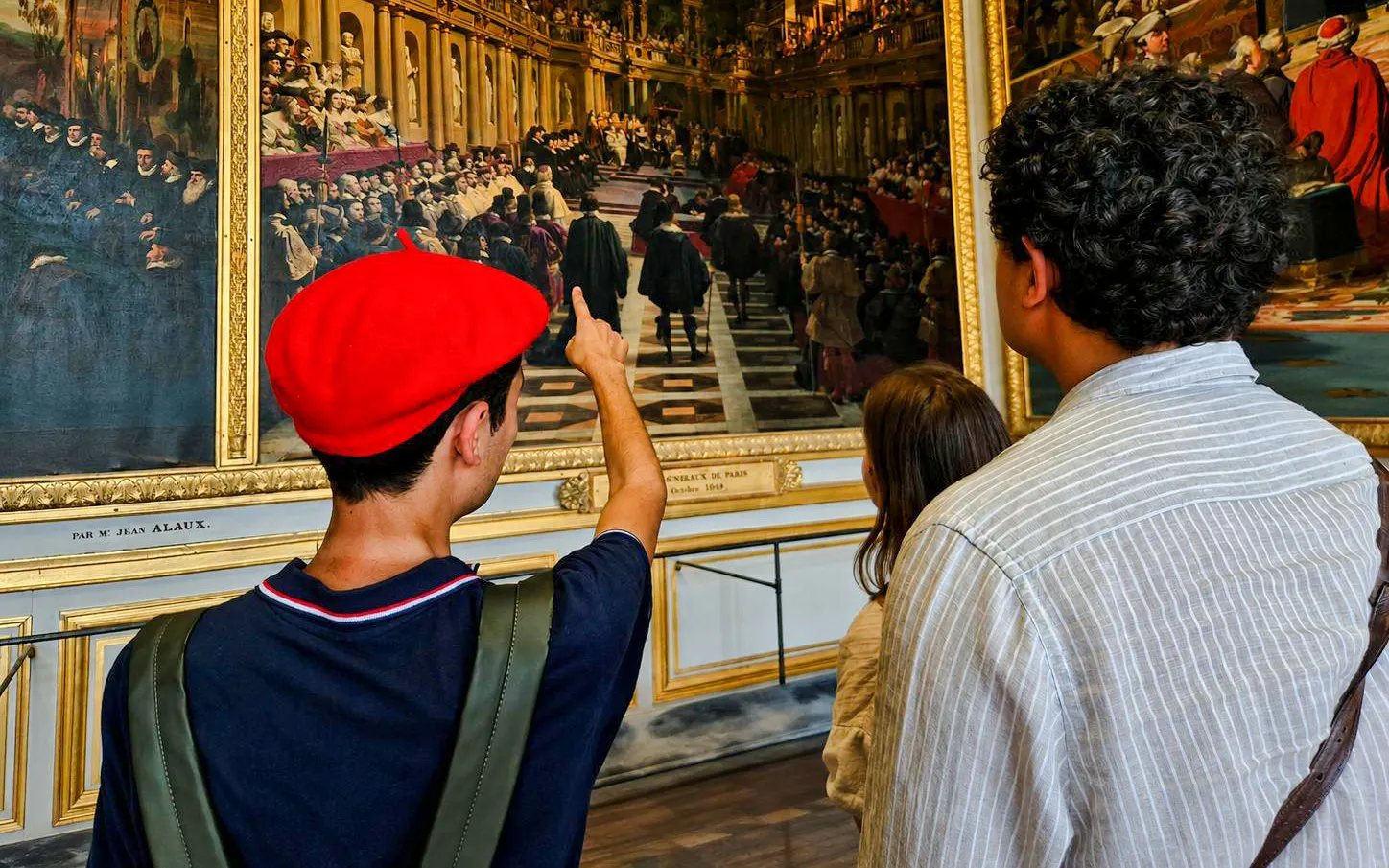 Visitors admire a historical painting during a private guided tour at Versailles Palace.