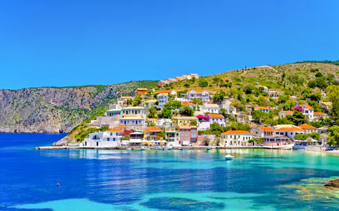 Colorful houses on the hillside of Assos Village, Kefalonia island, Greece, overlooking the turquoise sea.