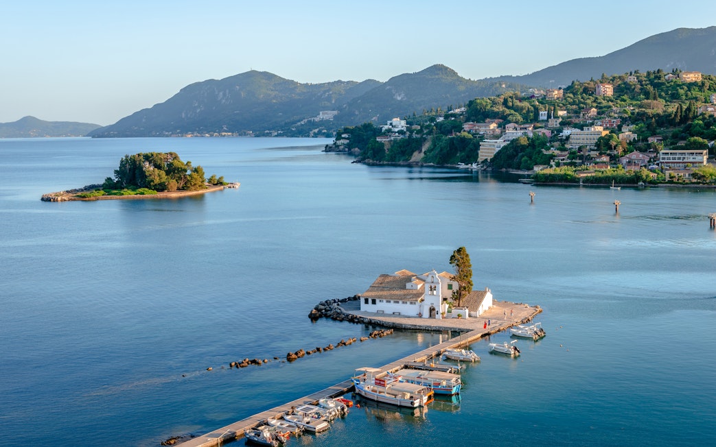 Mouse Island with Perama in the background, featuring a small dock and boats.