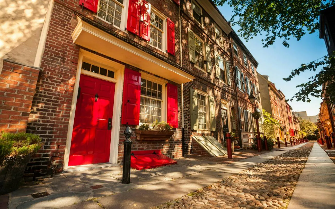 Historic brick row houses with red shutters in Philadelphia's Old Town.