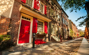 Historic brick row houses with red shutters in Philadelphia's Old Town.
